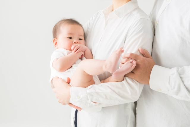 両親に抱かれる赤ちゃん